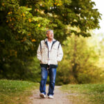 Happy senior man walking and relaxing in park