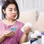 Woman reading the package insert of her medication to see if taking Zoloft® make her gain weight?